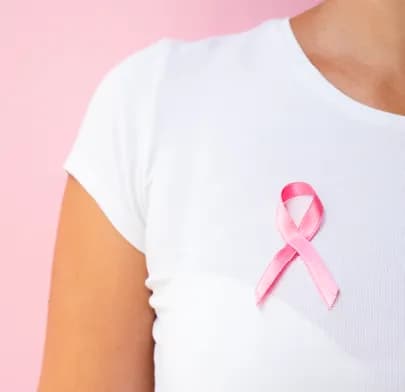 Person wearing a pink ribbon on a white shirt, symbolizing awareness and support for Basal Cell Cancer.